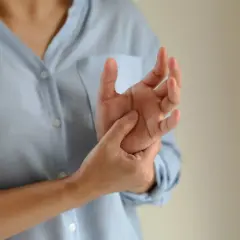 Dłoń masowana przez drugą dłoń, symbolizująca ból i dyskomfort związany z zespołem Ehlersa-Danlosa.