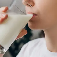 Kobieta pije mleko, szukając ulgi na zgagę.