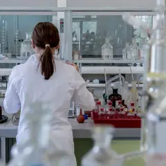 Naukowczyni w białym kitlu pracuje w laboratorium, gdzie analizuje próbki. Wyniki wskazują, że rdw-cv za niskie, co może sugerować pewne problemy.