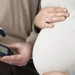 Para monitorować cukrzycę ciążową objawy, przyszła mama i partner kontrolują poziom glukozy glukometrem.