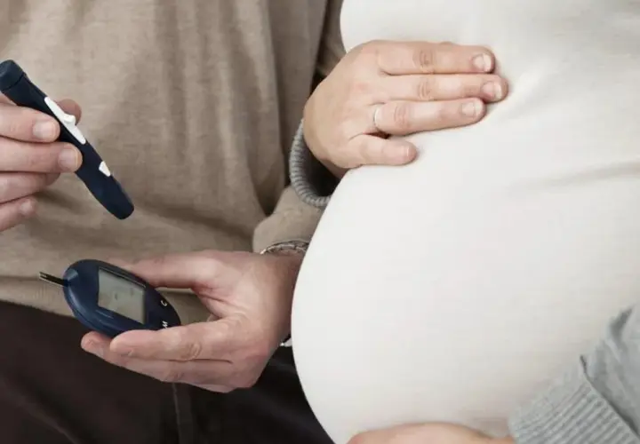 Para monitorować cukrzycę ciążową objawy, przyszła mama i partner kontrolują poziom glukozy glukometrem.