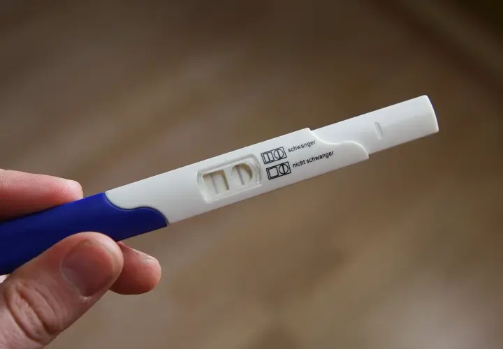 Test ciążowy z dwoma paskami, wskazujący na brak okresu i negatywny wynik.