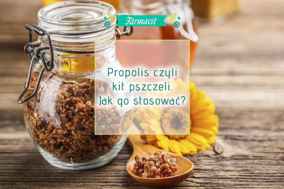 Słoik pełen propolisu, czyli kitu pszczelego, na drewnianym blacie. Obok żółty kwiat i łyżeczka z propolisem. Dowiedz się, propolis co to i jak go stosować.