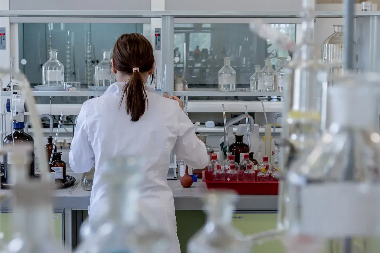 Naukowczyni w białym kitlu pracuje w laboratorium, gdzie analizuje próbki. Wyniki wskazują, że rdw-cv za niskie, co może sugerować pewne problemy.
